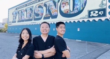 Three dentists with Fresno mural