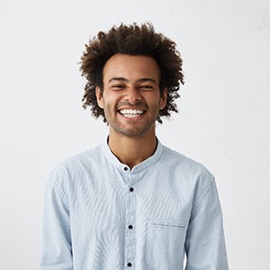 Man in light blue button-up shirt smiling