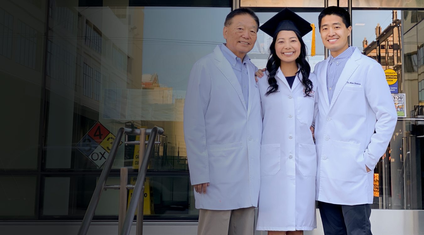 Fresno dentists wearing lab coats and smiling together outside of city building