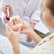 A patient holding a mockup of a dental implant