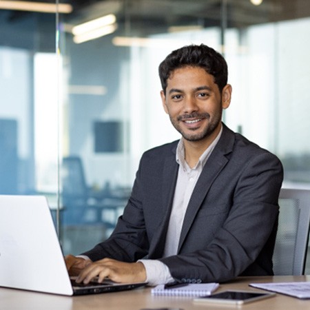 a smiling businessman sitting at a desk