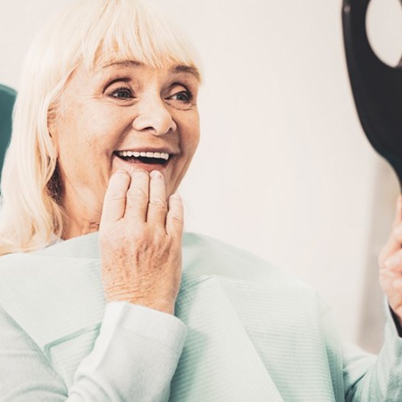 Woman admiring her new dental bridge in Fresno 