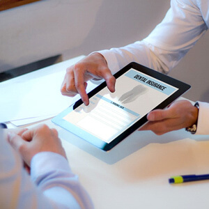 dentist and patient talking with a tablet with dental insurance on it