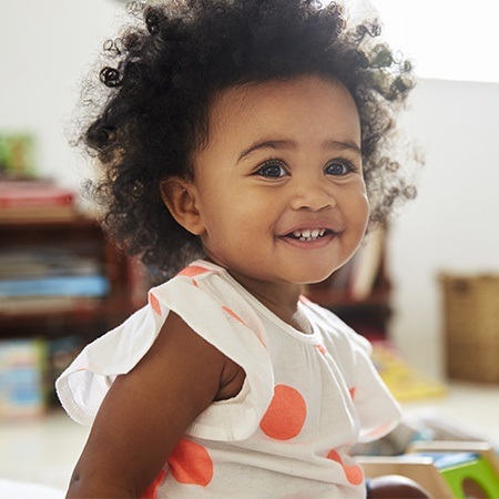 Little girl smiling after silver diamine fluoride treatment