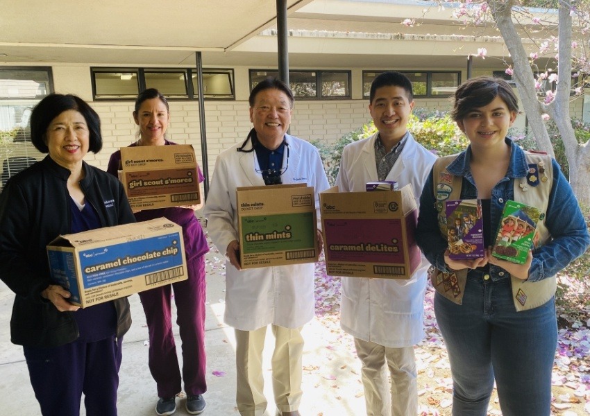 Team members buying Girl Scout Cookies to send to the troops