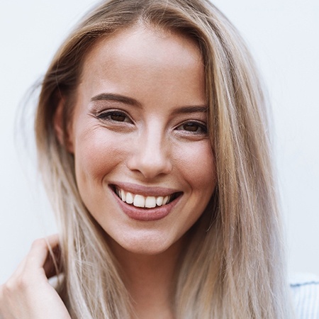 woman smiling after getting cosmetic dentistry in Fresno