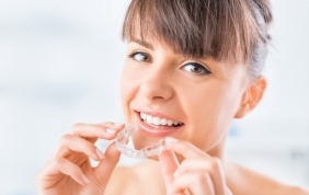 Woman holding Invisalign tray