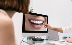 Dentist pointing to smile on computer screen