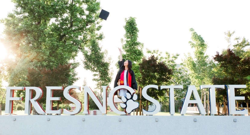 Doctor Shinkawa in dental cap and gown with Fresno State sign