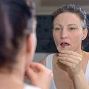 Woman placing a mouthguard into her mouth