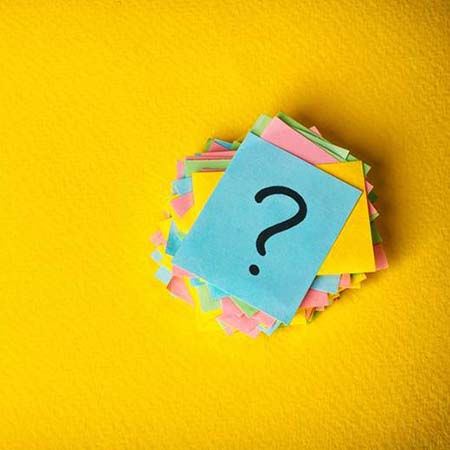 Stack of sticky notes with question marks on them