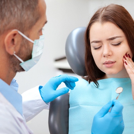 Woman visiting an emergency dentist in Fresno for tooth pain