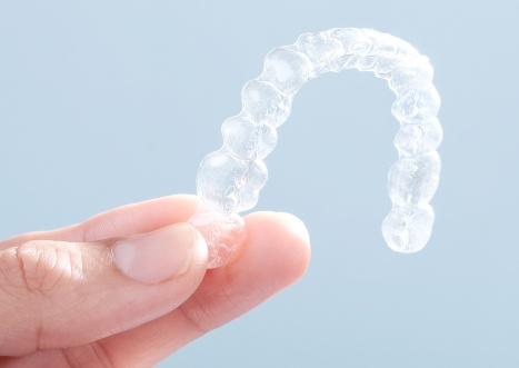 Hand holding an Invisalign tray