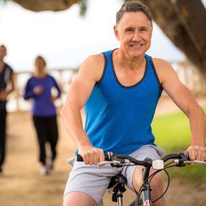 Older man riding a bicycle on an outdoor trail