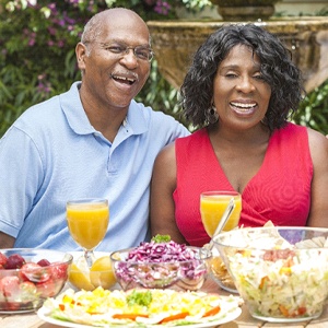 Older couple enjoying meal after visiting implant dentist in Fresno