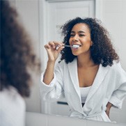 Woman brushing teeth in Fresno