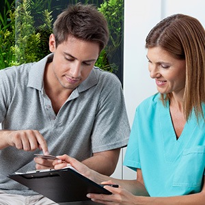 Dental team member showing patient a tablet