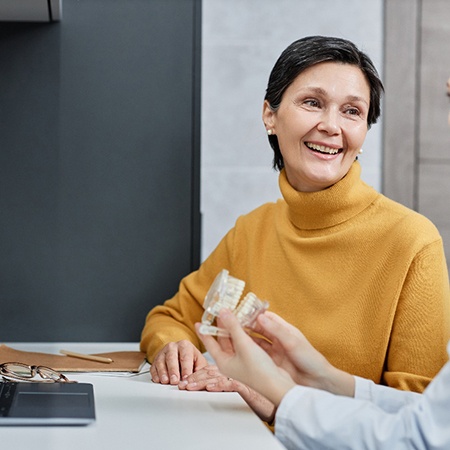 Someone holding implant dentures