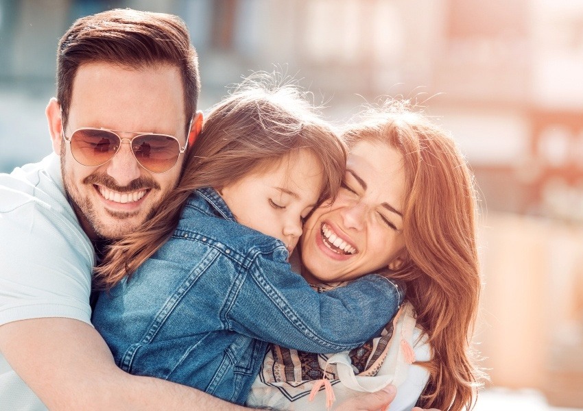 Family of three hugging each other