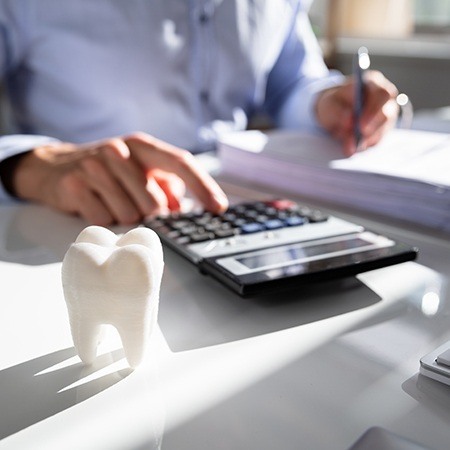 Dentist calculating dental insurance coverage