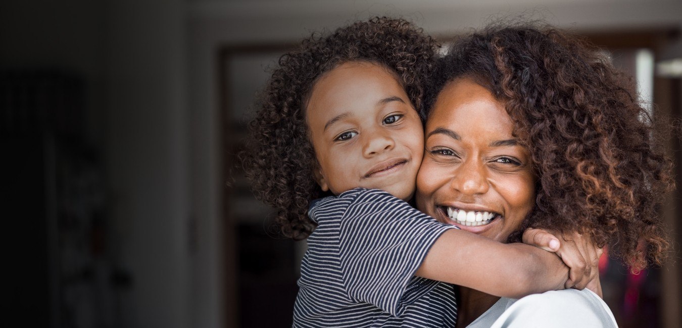 Mother giving her daughter a hug after children's dentistry treatment