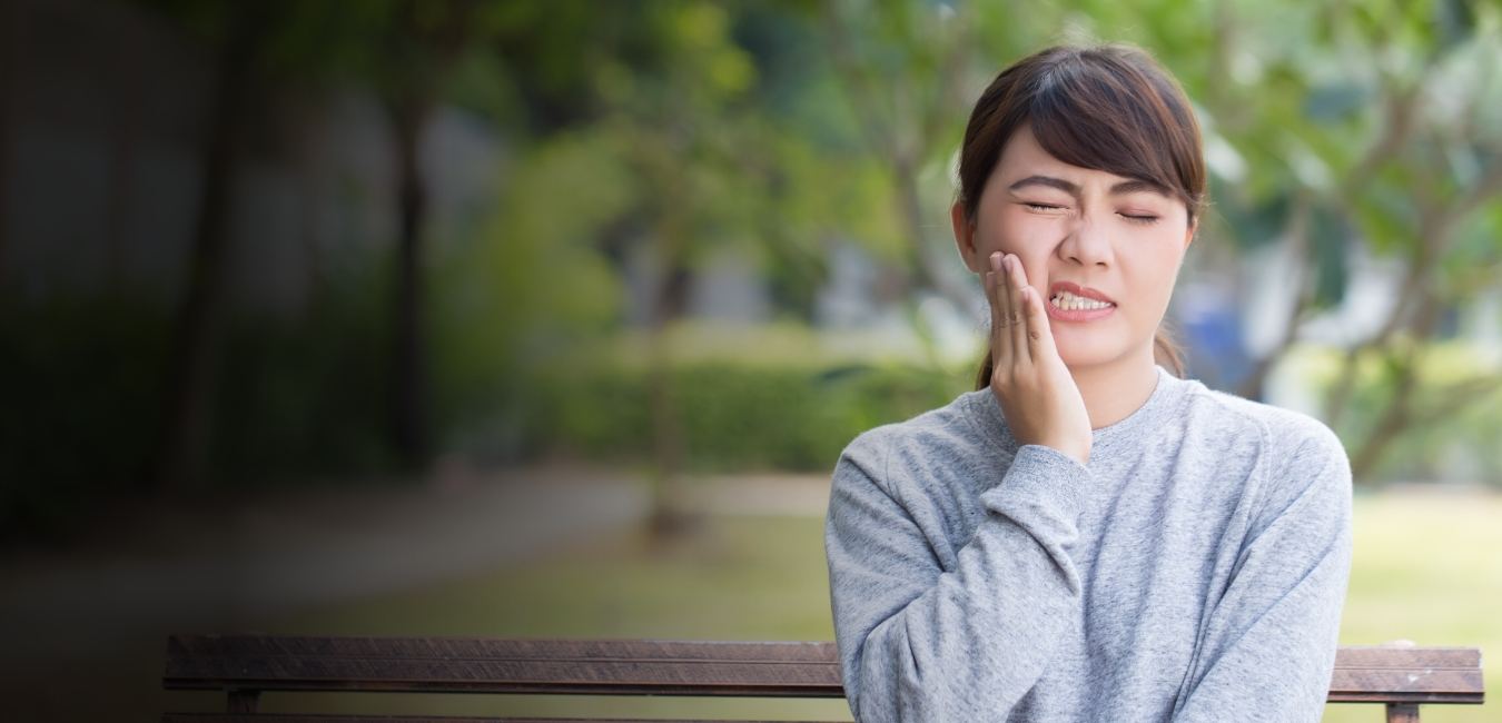 Woman with a toothache in Fresno while sitting outside