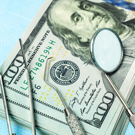 Dental tools lying on pile of cash