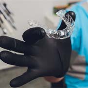 Invisalign dentist in Fresno holding a clear aligner