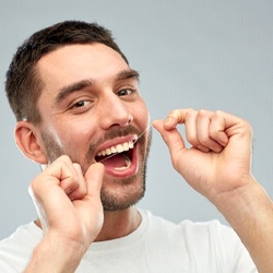 Man with Invisalign in Fresno flossing