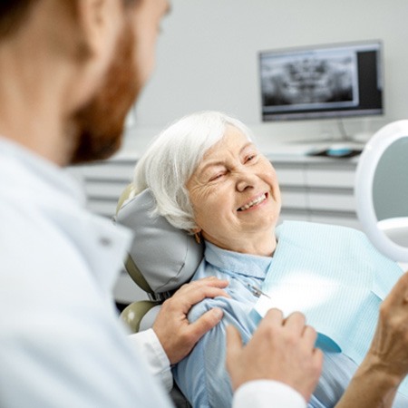 An elderly woman happy with her new dental implants