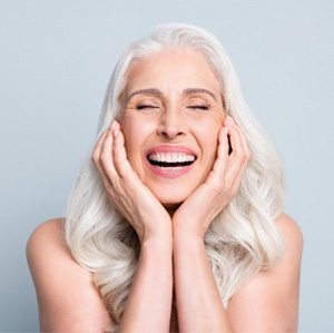 A happy woman whose dental implants have fused with her jaw