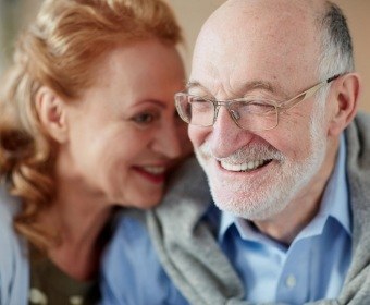 Man and woman smiling after replacing missing teeth