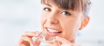 Woman holding Invisalign tray