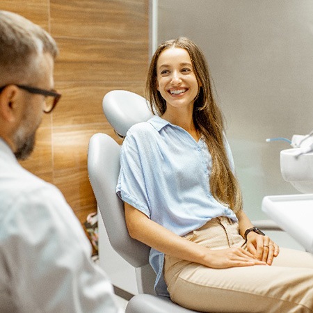Woman smiling at cosmetic dentist during consultation