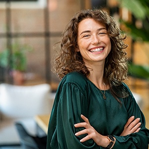 Woman in green shirt smiling in a lobby