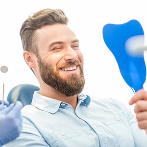 Male patient checking his smile in a mirror