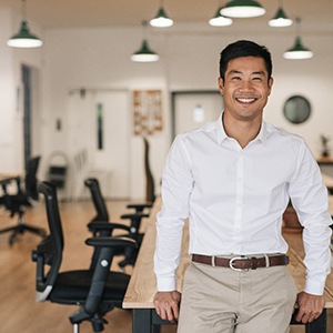 Man in white shirt smiling in a meeting room
