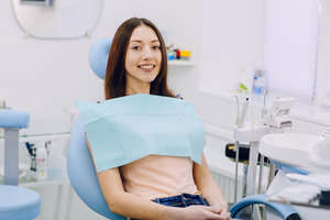 Female patient sitting in a dental chair smiling