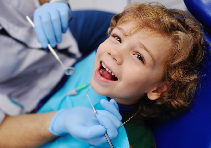 Child smiling while undergoing dental exam