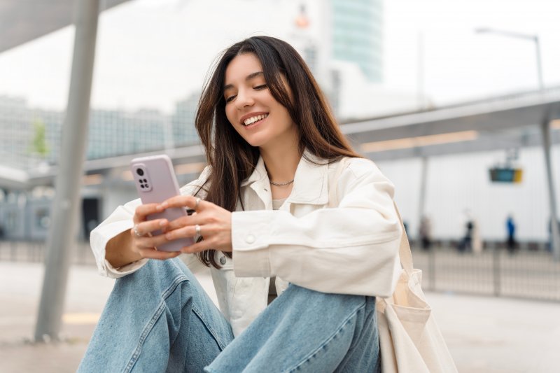 Smiling lady reads information on phone