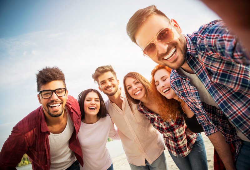 Invisalign patient smiling with friends in summer